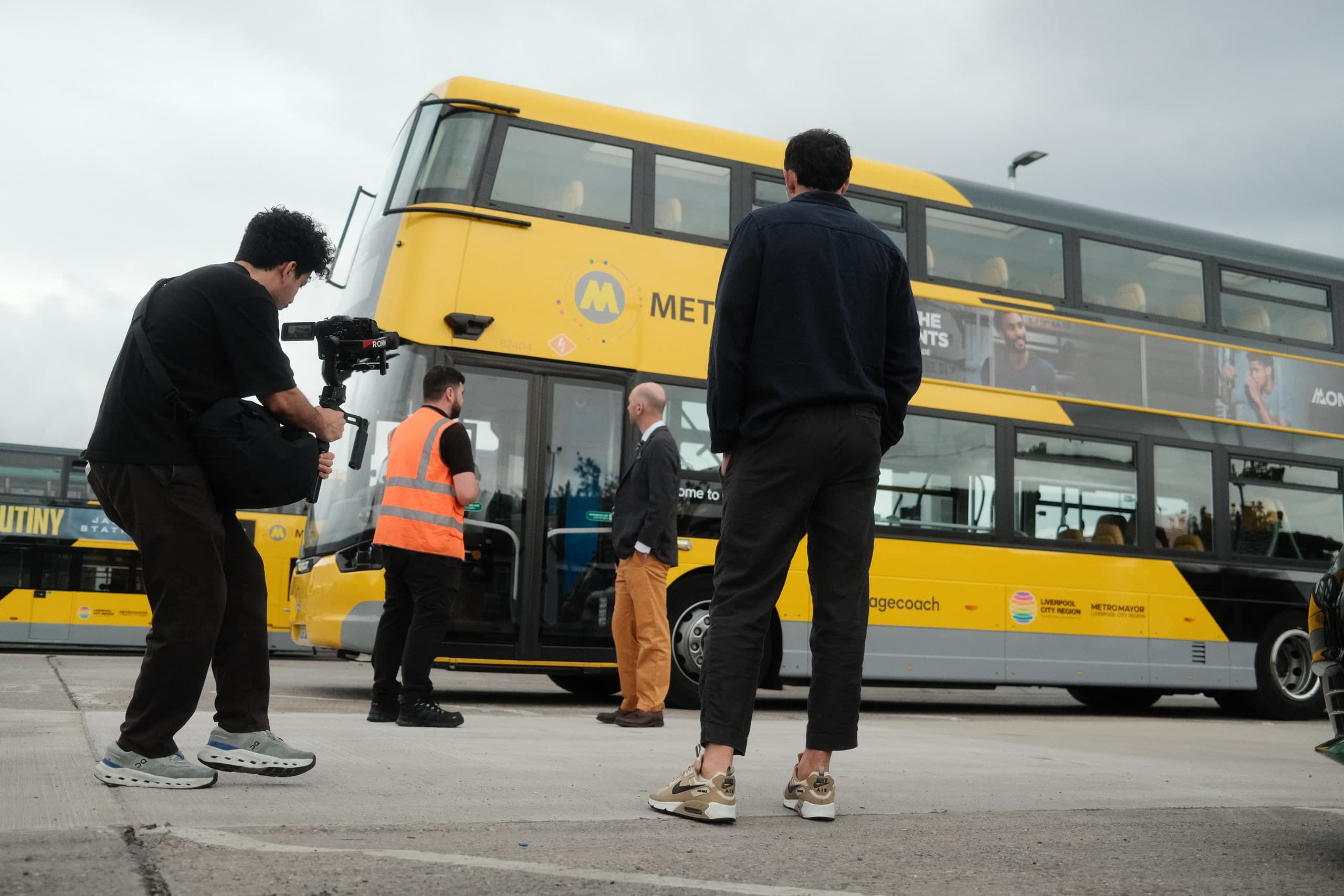 Filming beside a yellow double-decker bus