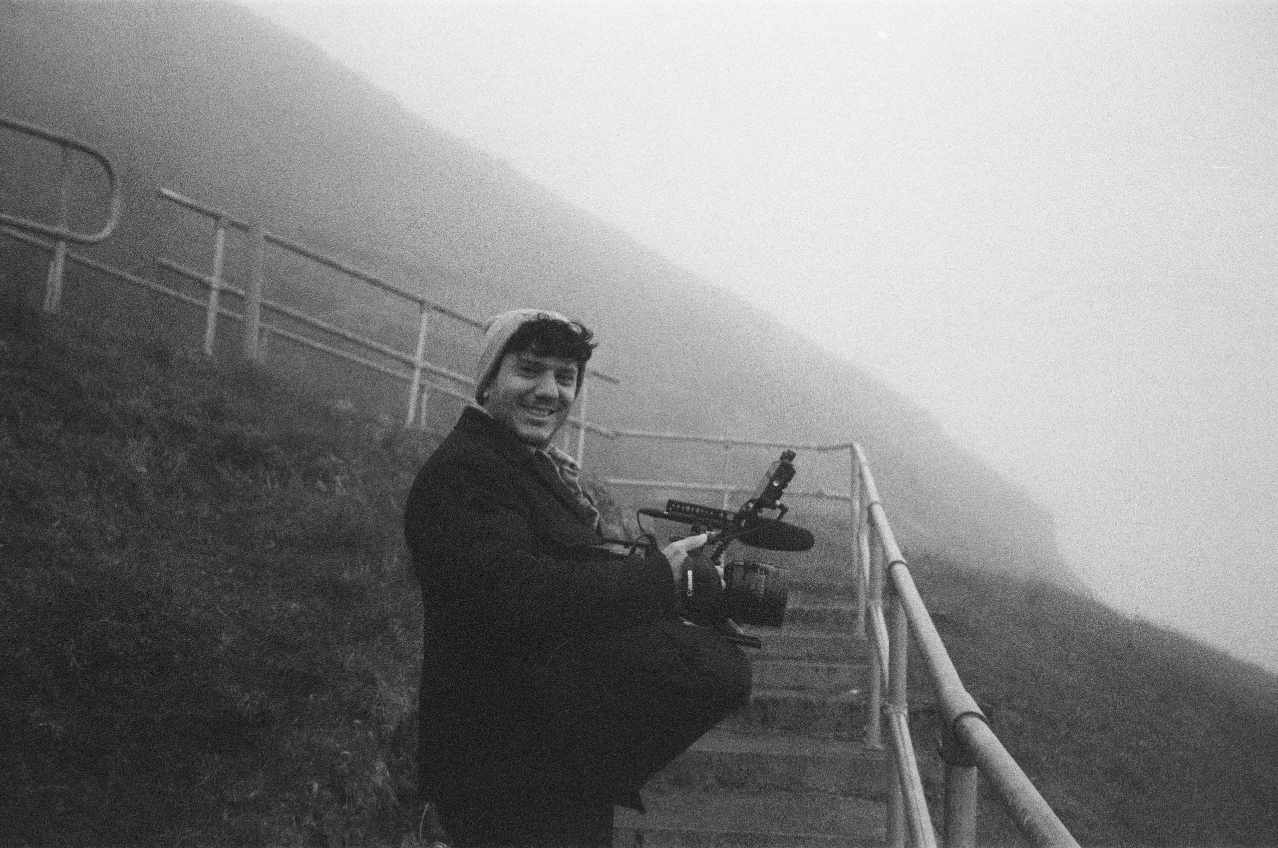 Filming on a misty hillside, in black and white