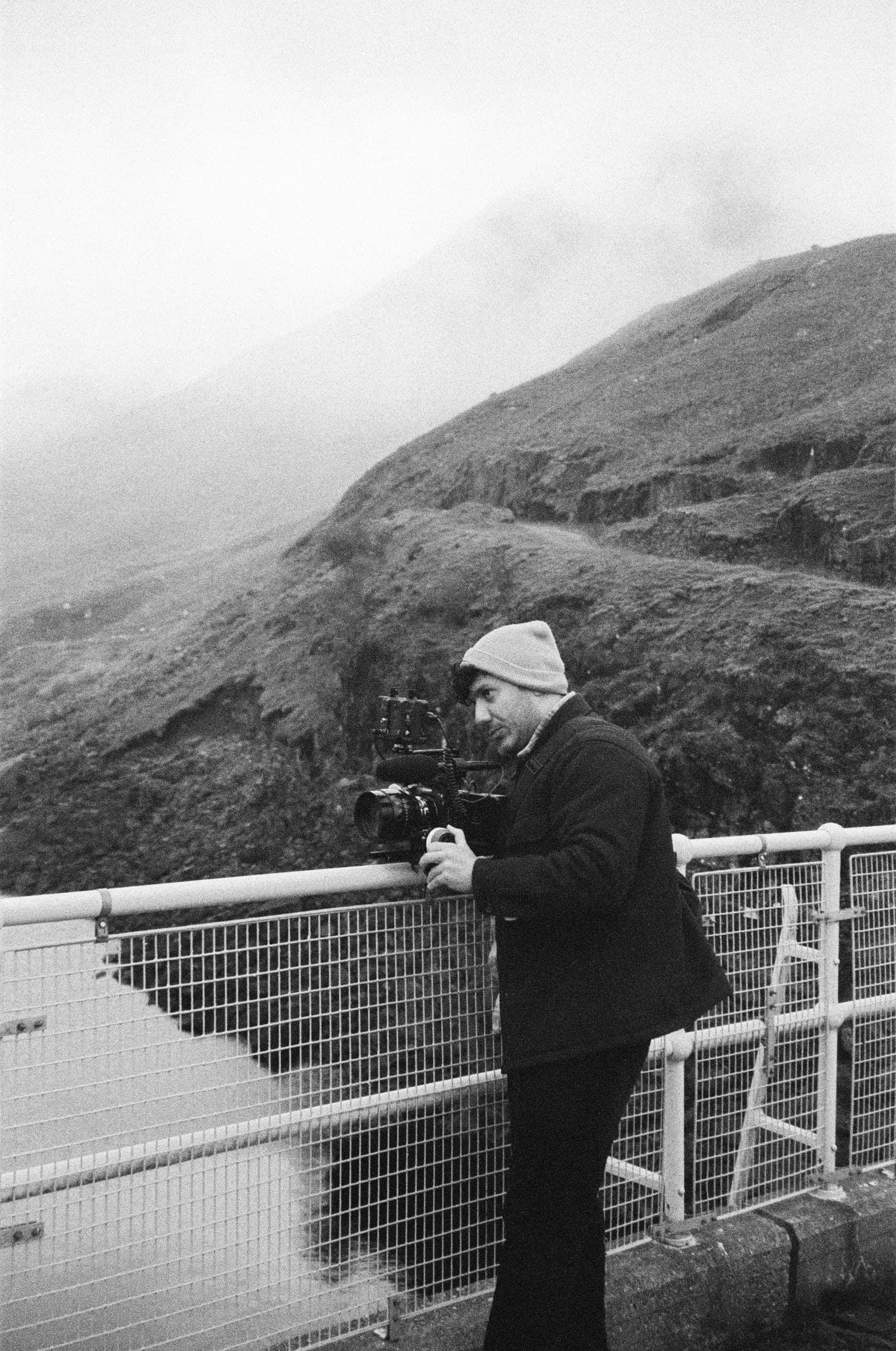 Filming from a railing on a misty path, in black and white